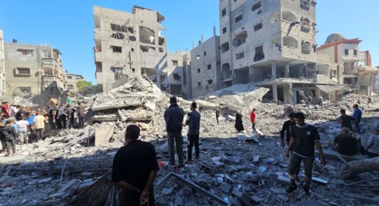 Palestinos se reúnen en el lugar de los ataques israelíes contra casas y edificios residenciales en Beit Lahiya, en el norte de la Franja de Gaza