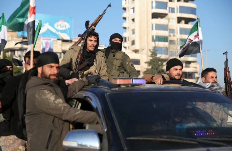Rebeldes viajan en un vehículo en la ciudad de Alepo, en el norte de Siria (Omar HAJ KADOUR/AFP)