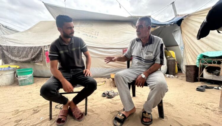 Samer Al Masry, de 63 años, empleado público jubilado, con su hijo Mohammed, de 31 años, ingeniero civil, en la tienda que comparten en Al Mawasi, Gaza, el 9 de octubre.Mohamed Solaimane